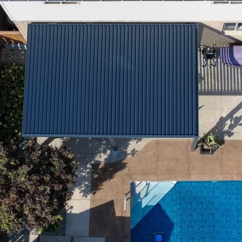 Louvered pergola beside a pool, seen from above