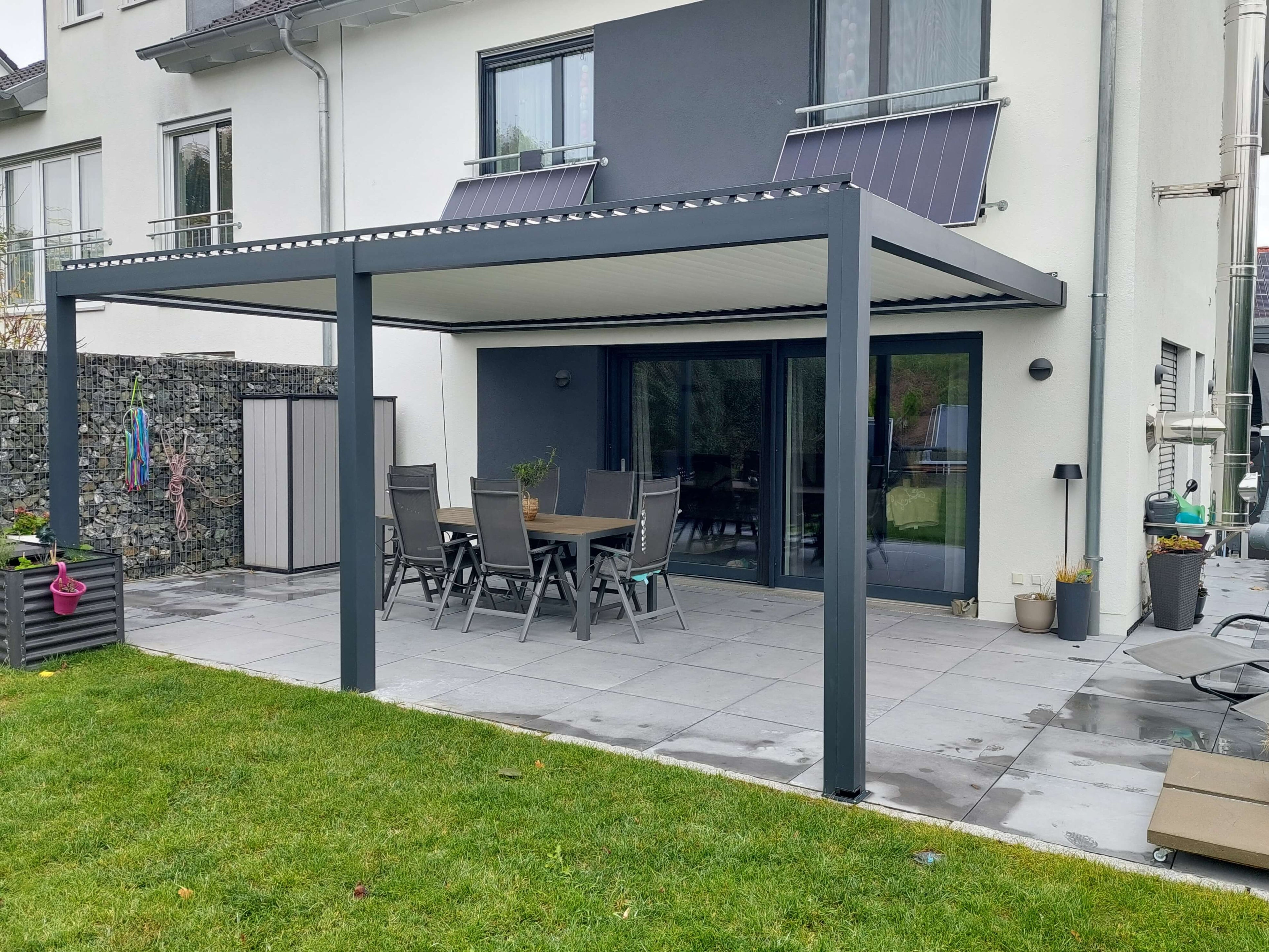 Anthracite pergola over a terrace dining set