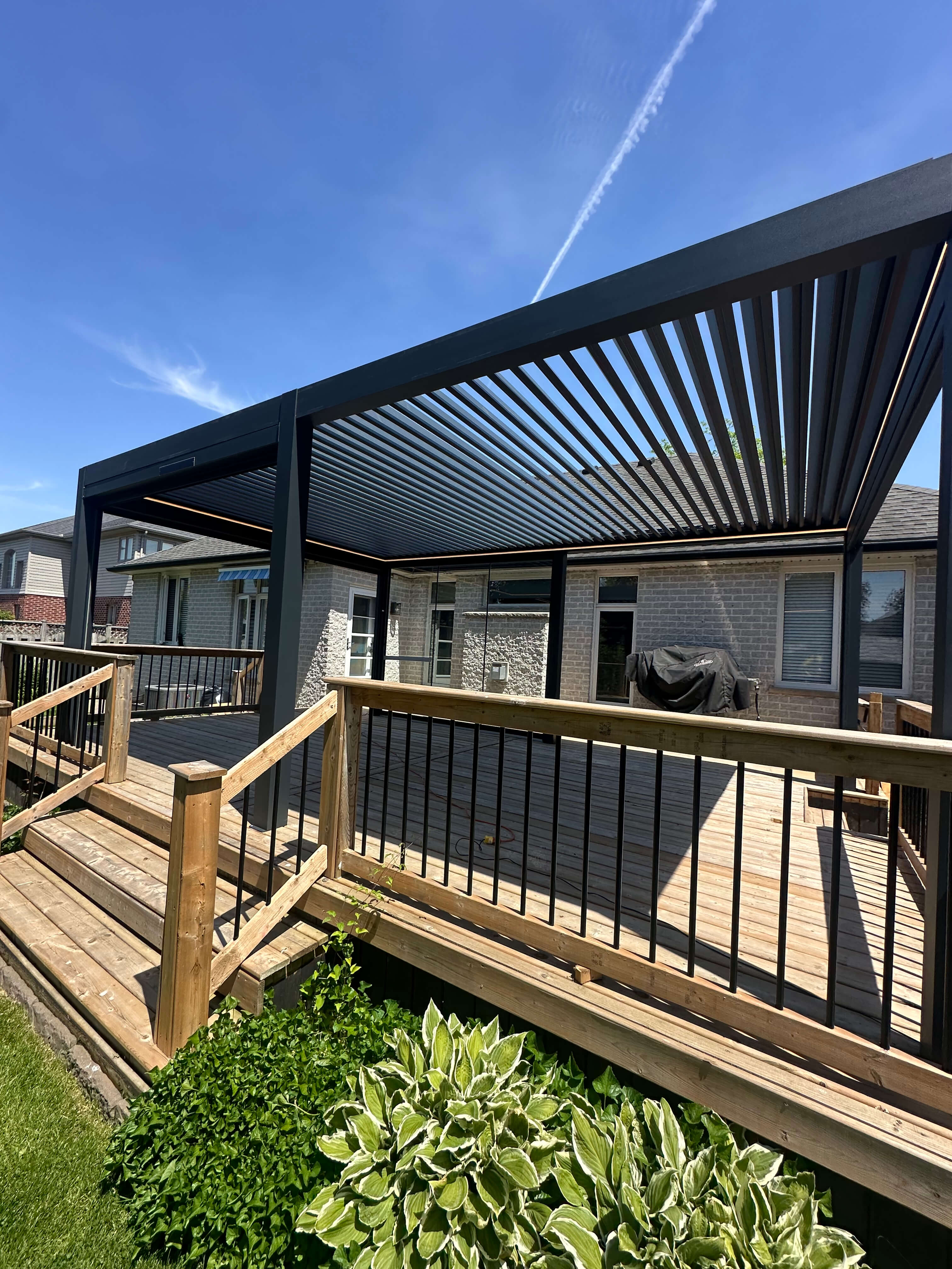 Installed louvered pergola on a wooden deck