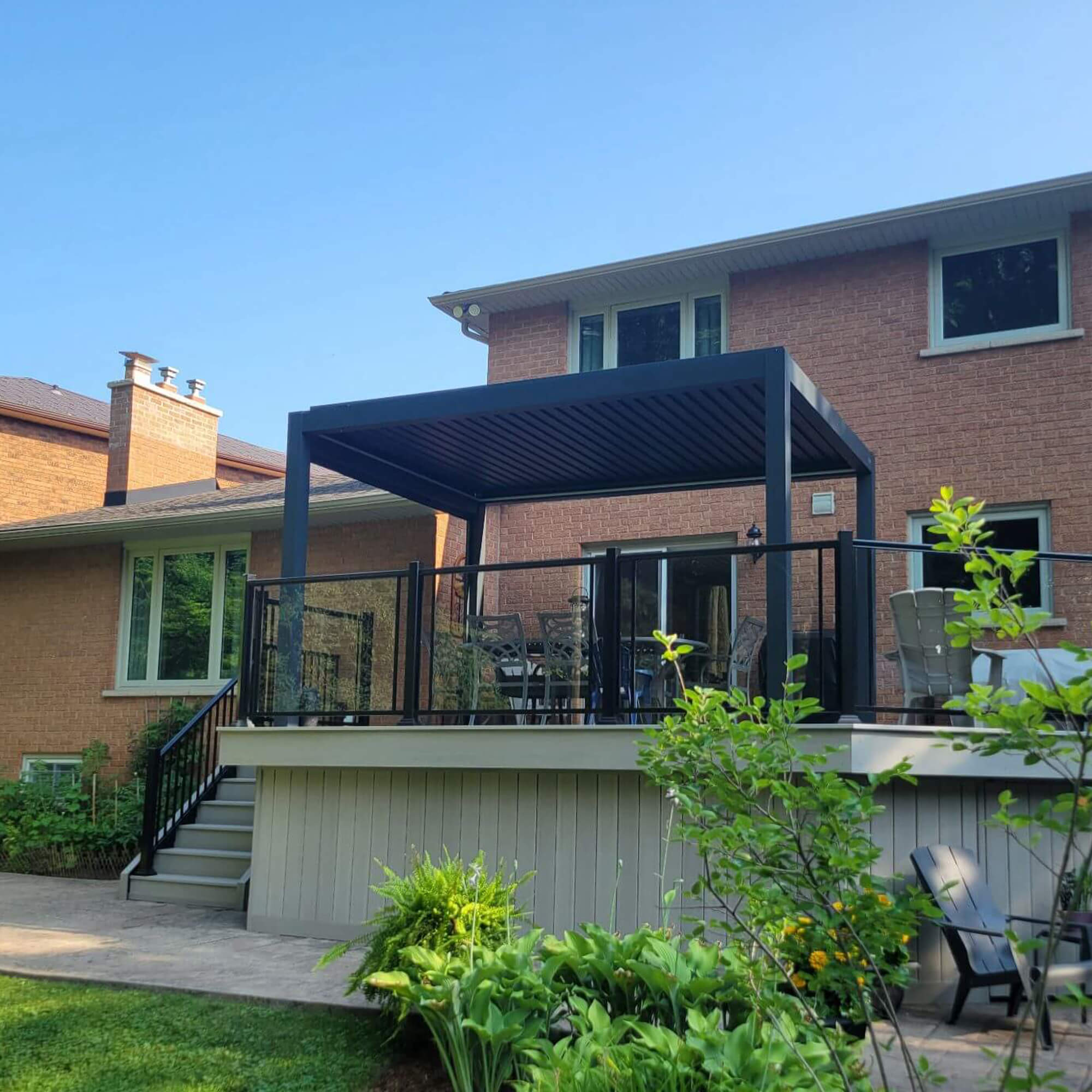 Manual louvered pergola installed over a raised backyard deck