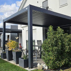 Anthracite manual louvered pergola over a patio seating area