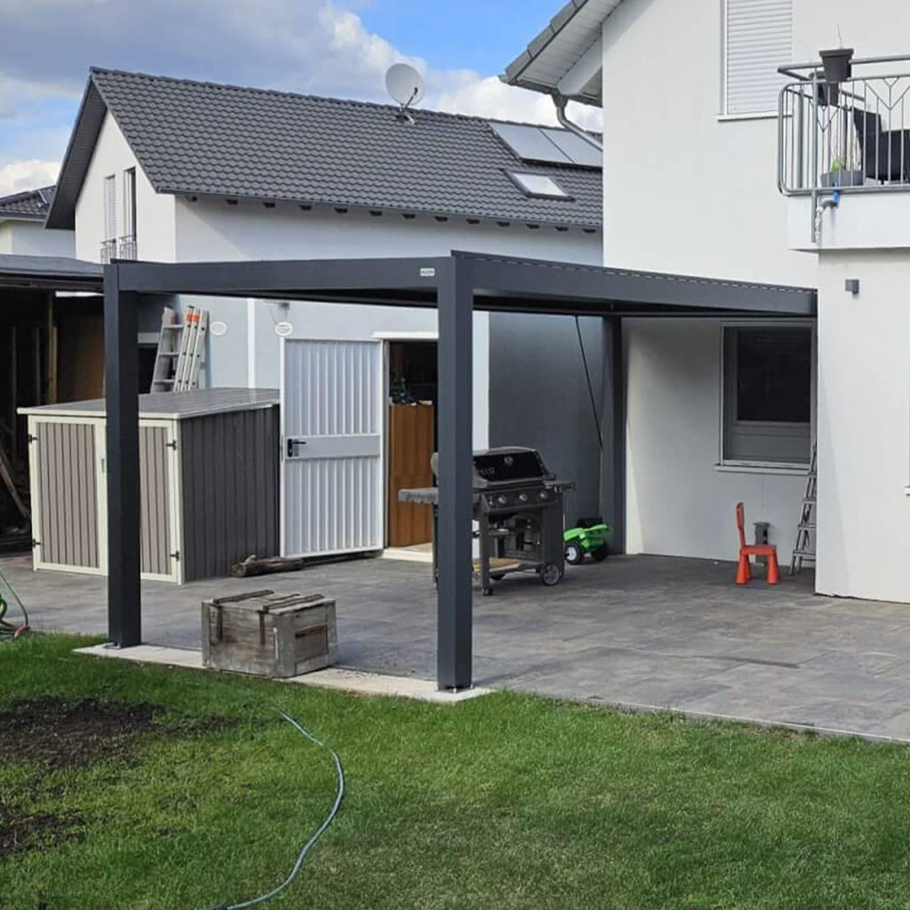 Anthracite manual louvered pergola on a backyard terrace